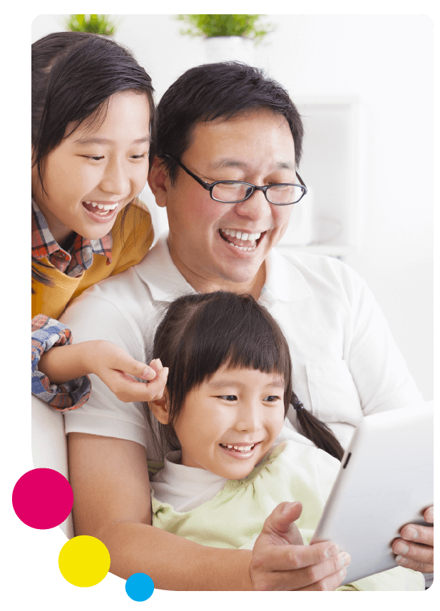 A father and his daughters learn English at home with Little Bridge on a tablet