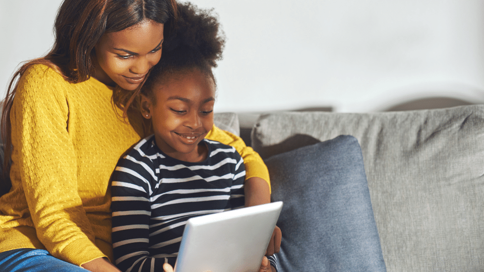 Parent at home helping child learn English with Little Bridge